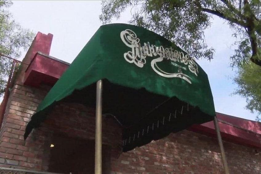 Un toldo verde con el texto 'Gourmet' y un logotipo. 3