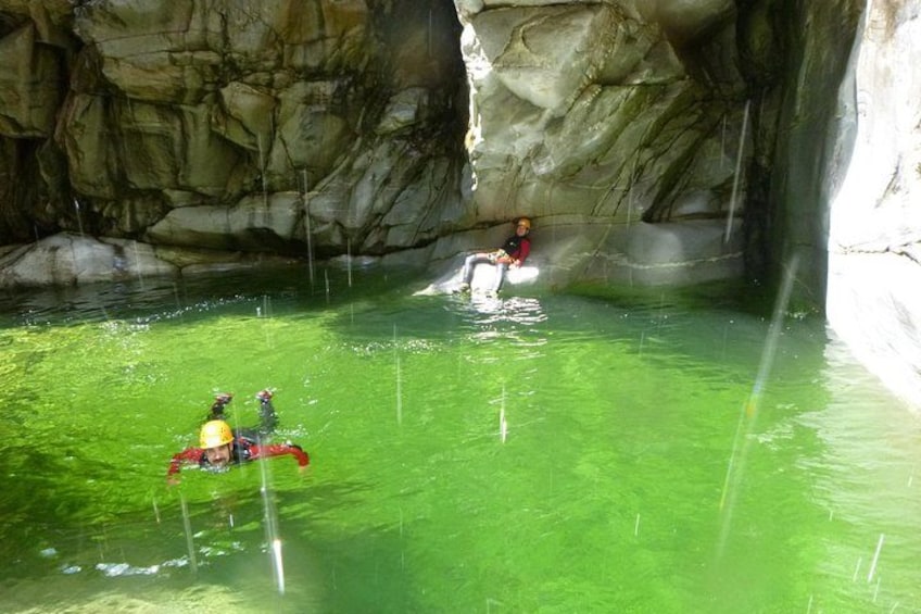A cave with green water and people kayaking. 1