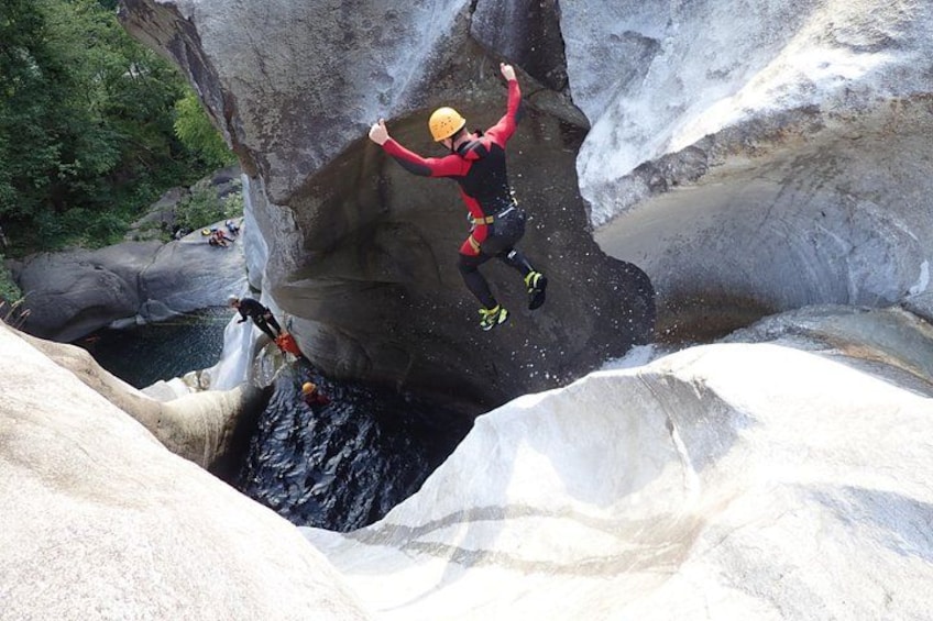 A person rappelling down a large rock formation. 3
