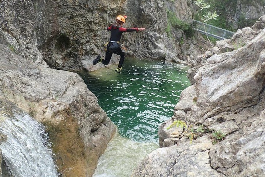 A person jumping from a rock into a river. 2