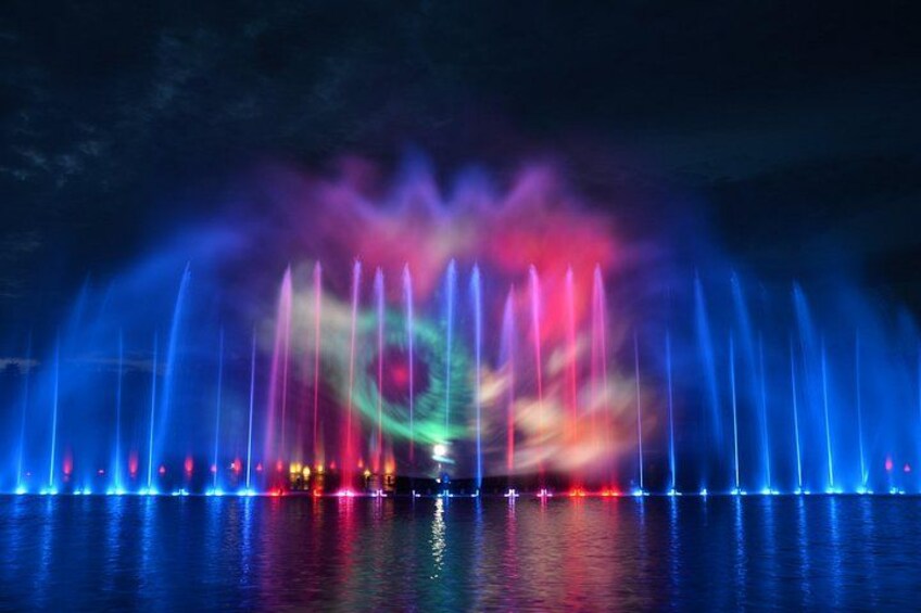 A nighttime water fountain display with colorful lights reflecting on the water. 1