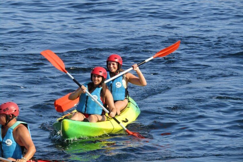 Three people kayaking on a body of water. 3