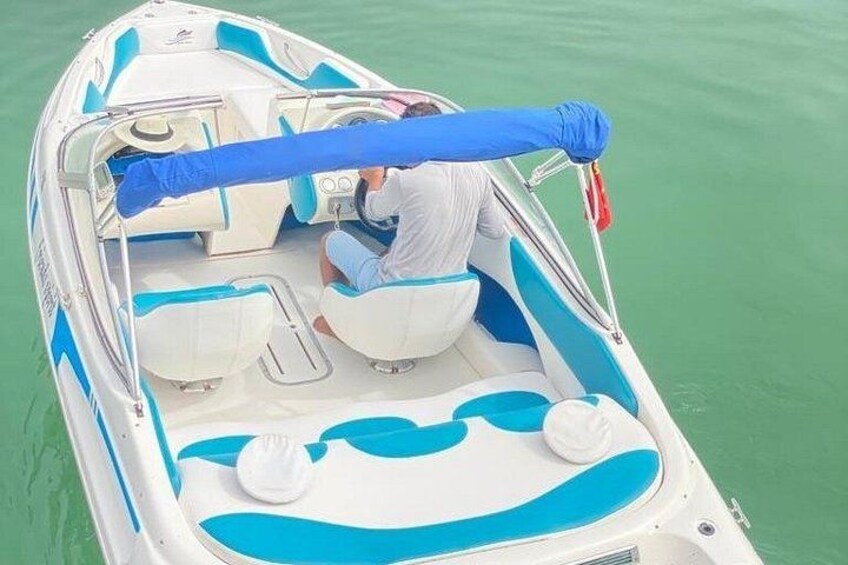 Una pequeña lancha con toldo azul, dos asientos blancos y un timón. 4