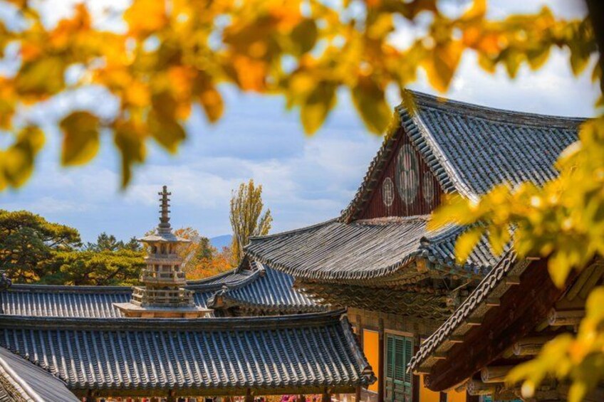 Traditional Japanese architecture with tiled roofs and a pagoda. 2