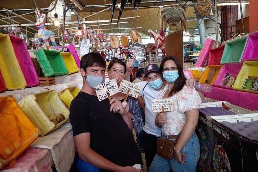 Ein Markt mit bunten Textilien und Menschen mit Schildern. 5