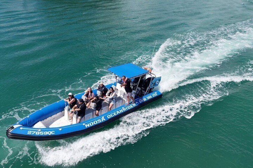 Un bateau bleu transportant des passagers, portant l’inscription « House Ocean Adventure », navigue sur une eau turquoise. 5