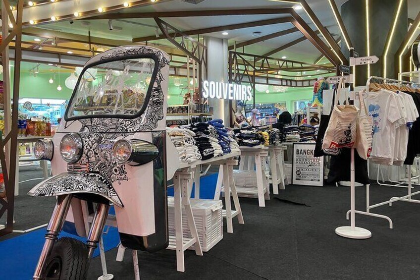 A souvenir stall with a motorcycle display and clothing racks. 4
