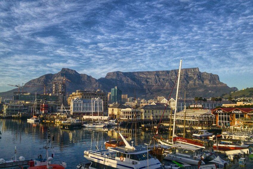A harbor with boats, a mountain in the background, and buildings with signs like 'CAFE' and 'UNION'. 2