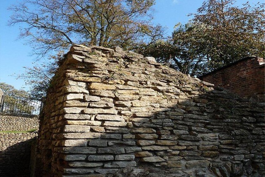 Een stenen muur met een bakstenen structuur erachter. 2