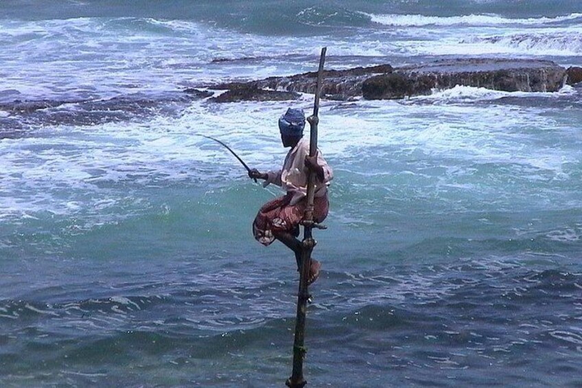 A person fishing with a rod and a bag of bait. 1