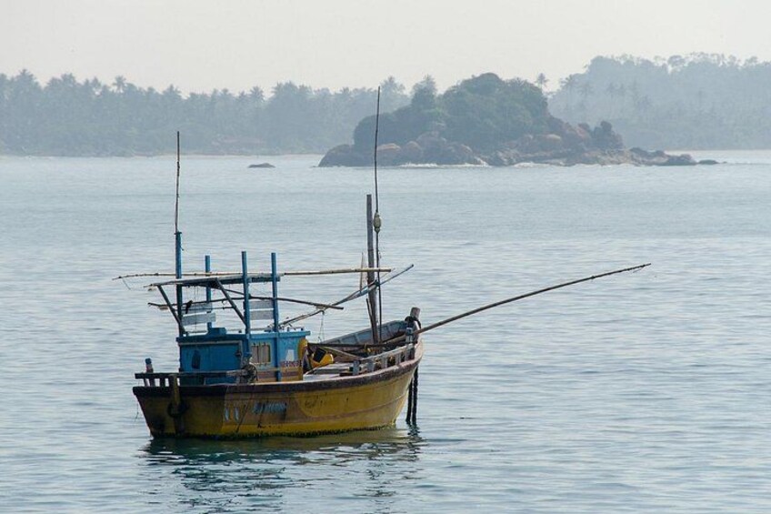 A small fishing boat with a blue cabin and a fishing rod on calm water. 3