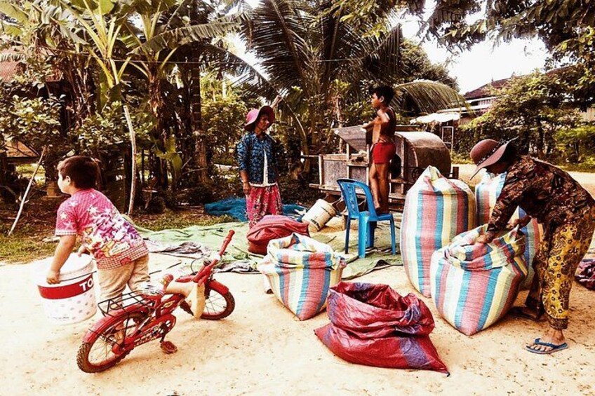 Escena rural al aire libre con gente, una bicicleta y bolsas de mercancías. 1