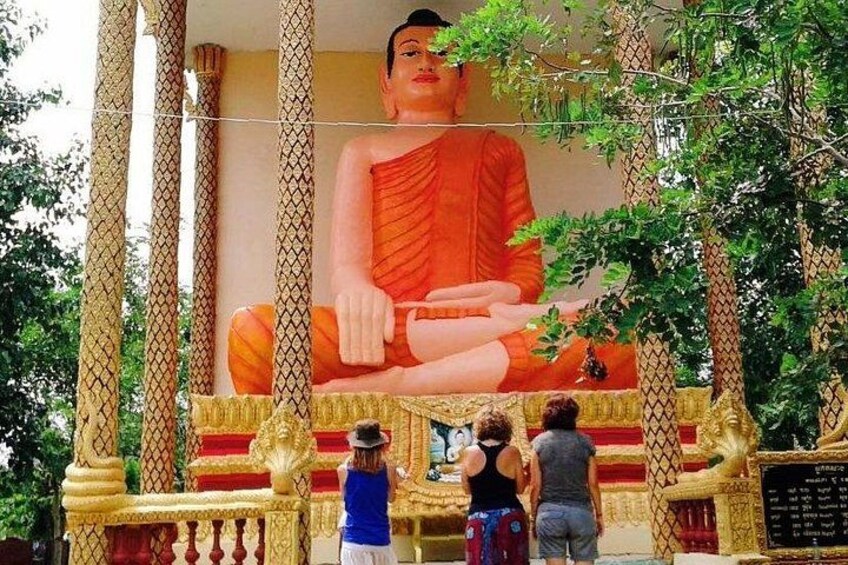 A large Buddha statue, a golden railing, and a tree. 3
