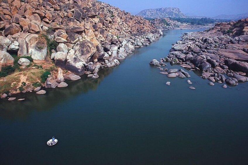A river with large rocks and a boat. 4