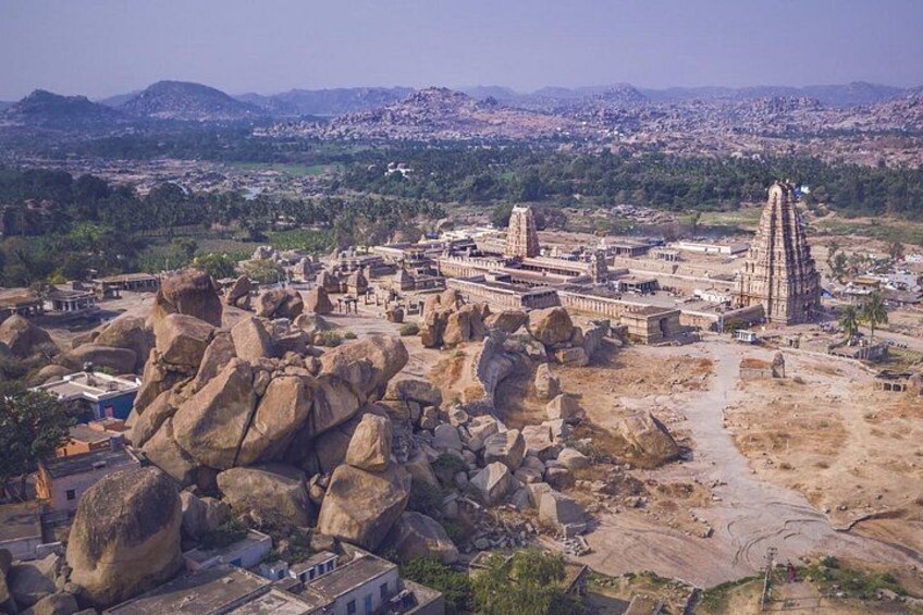 An ancient temple complex with large rock formations and a prominent tower. 1