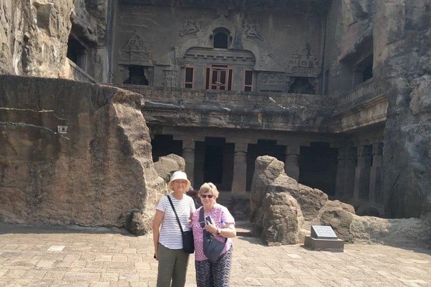 A historical building with carved rock faces and a large rock formation. 5