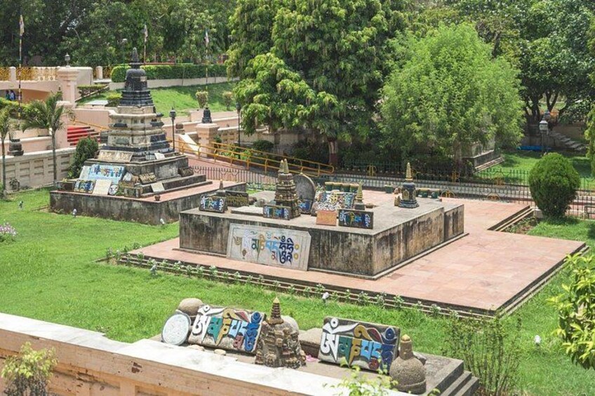 A park with a pagoda, a stone monument, and a well-maintained lawn. 4