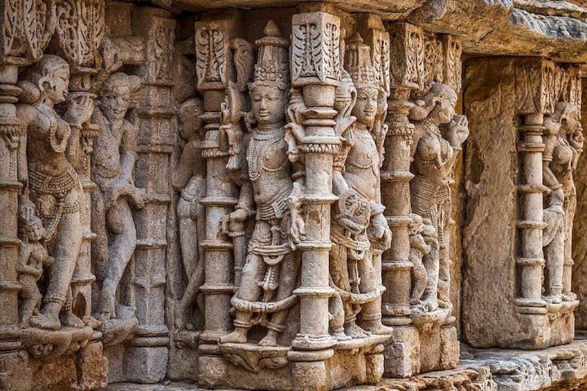 A detailed stone carving of deities and figures in a temple. 4