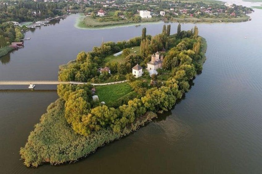 Een eiland met gebouwen en bomen, omringd door water. 1