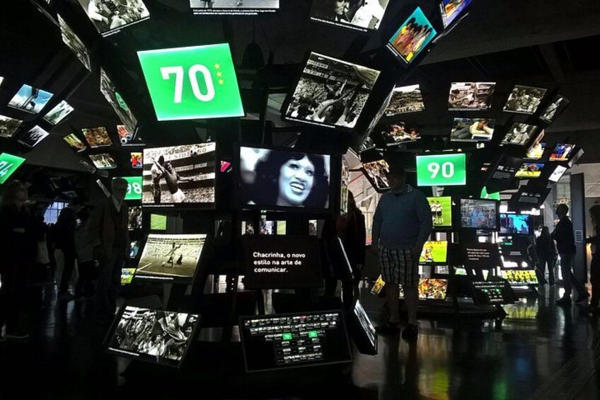 A museum with multiple display cases and digital screens, including signs with numbers 70 and 90. 5