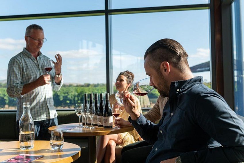 Un grupo de personas degustando vino en una mesa con vistas panorámicas. 5
