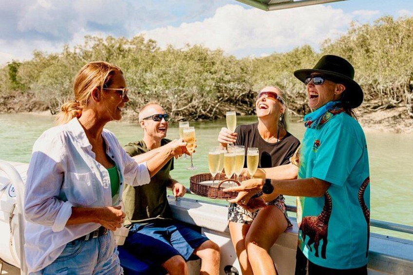 A group of people on a boat, toasting with drinks. 1