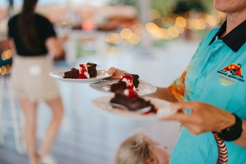 A person holding a plate with a slice of cake and a spoon. 2
