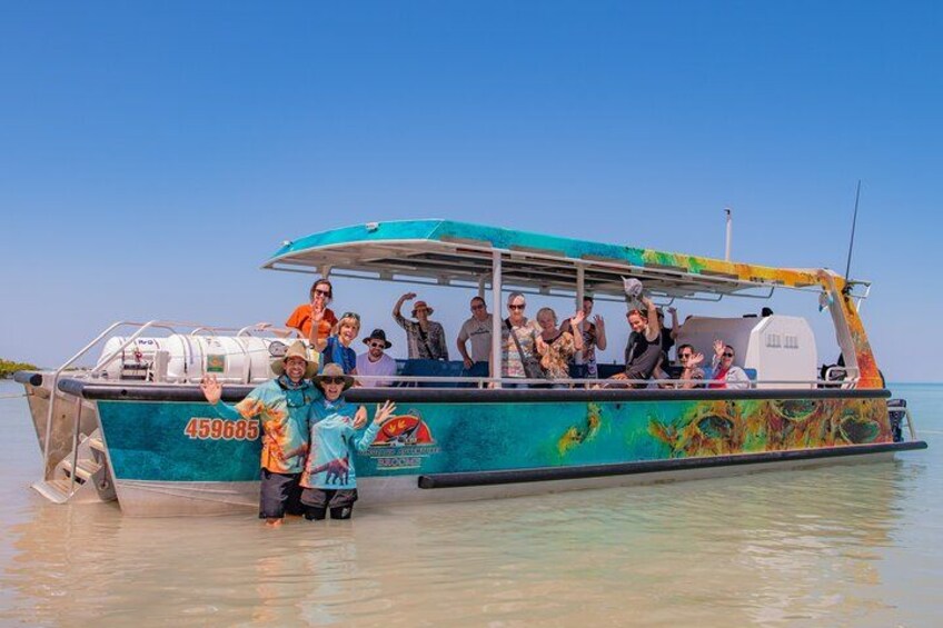 A colorful boat with people on board, a clear blue sky, and calm water. 4