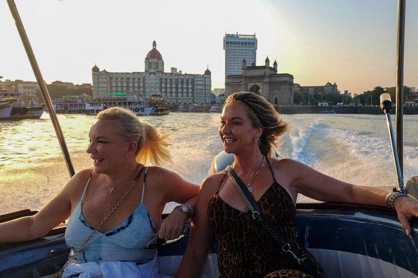 Two people on a boat with a cityscape in the background. 2
