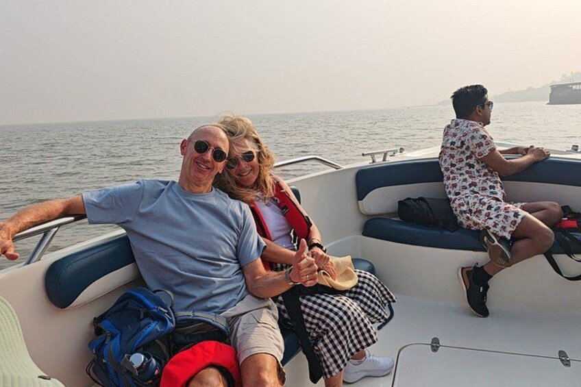 A boat with two people sitting on the deck, one wearing a red life jacket. 5