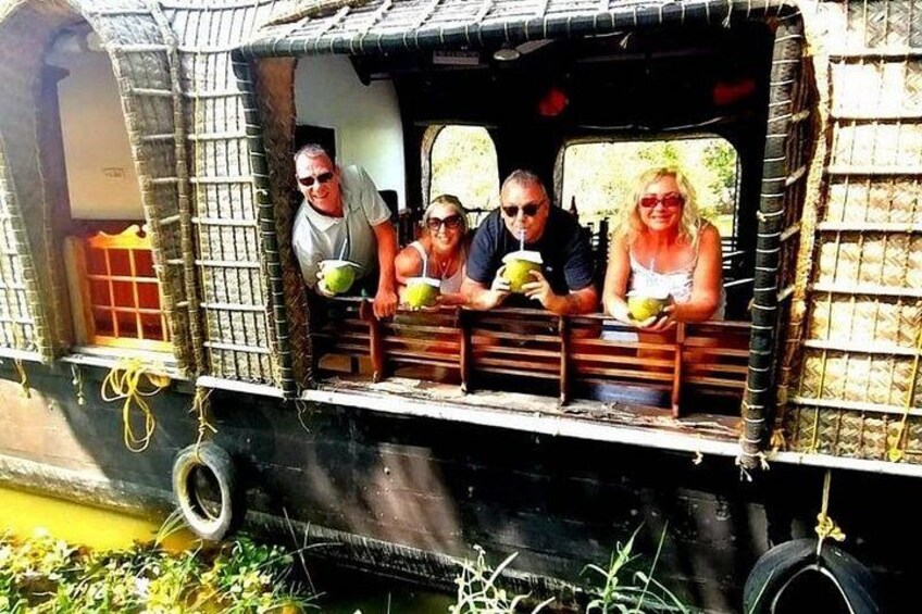 A rustic boat with passengers holding coconuts. 3