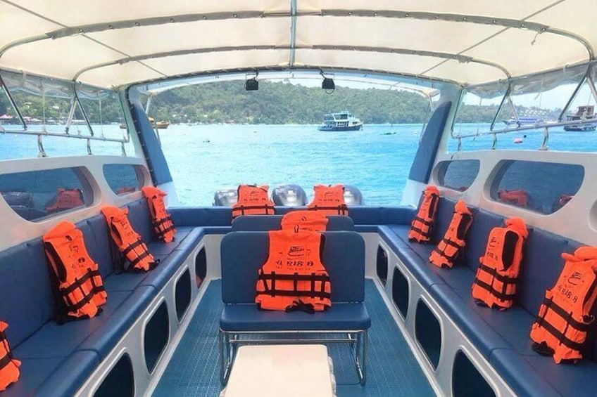 A boat interior with rows of orange life jackets and a view of the water and other boats. 4