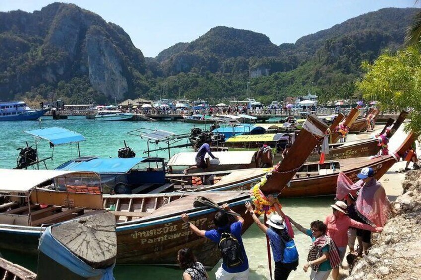 A coastal scene with traditional boats docked at a pier, surrounded by lush greenery and mountains. 5