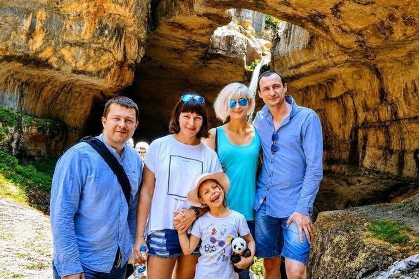 Una familia parada frente a una formación rocosa natural. 1