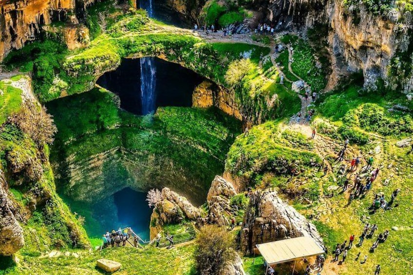Un paisaje exuberante con un cascada, una piscina cristalina y una plataforma de observación. 4