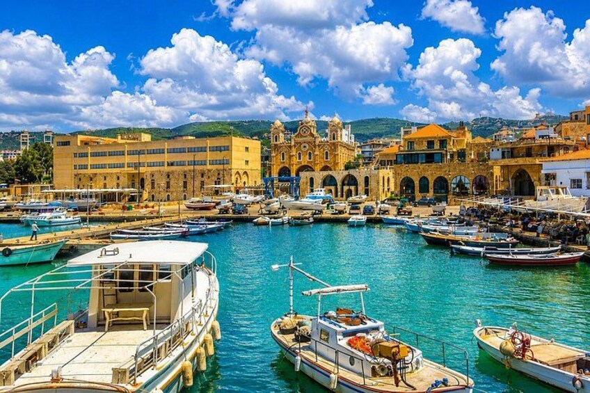 A harbor with boats docked, a prominent church, and a clear blue sky. 2