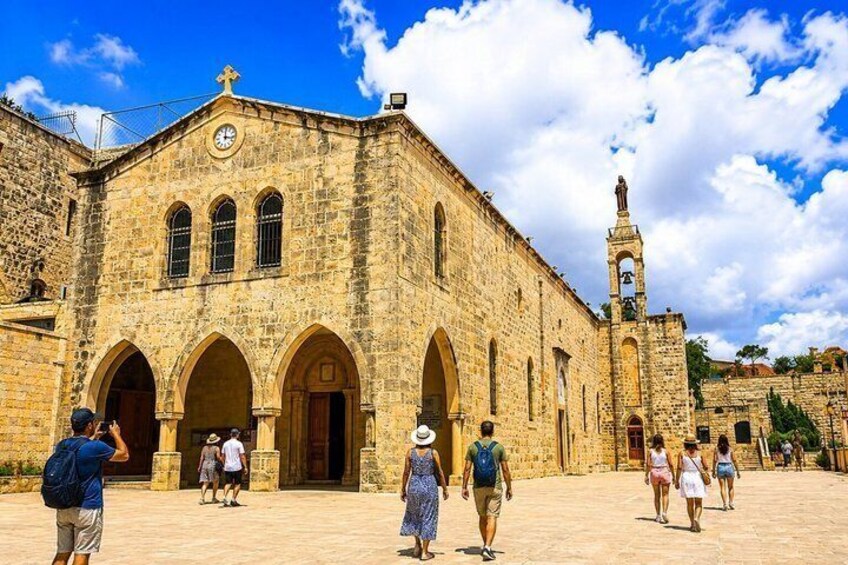 A historic stone building with arches, a clock, and a bell tower. 2