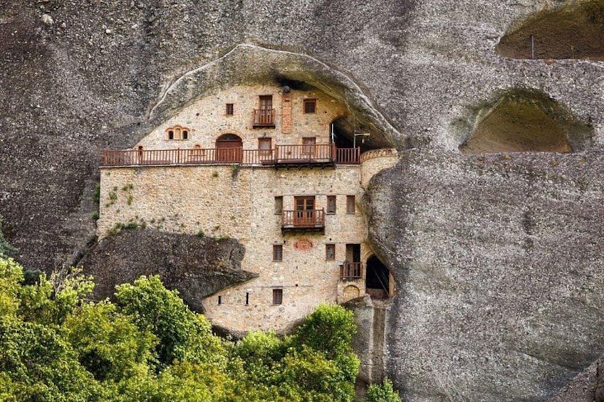 A building carved into a rock formation with balconies and windows. 4