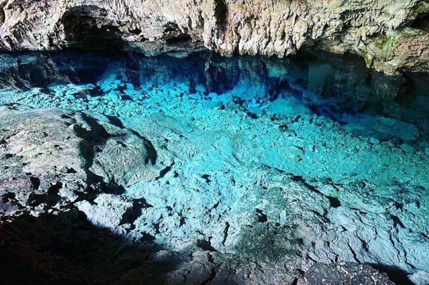 Una grotta con acque cristalline blu e formazioni rocciose. 3