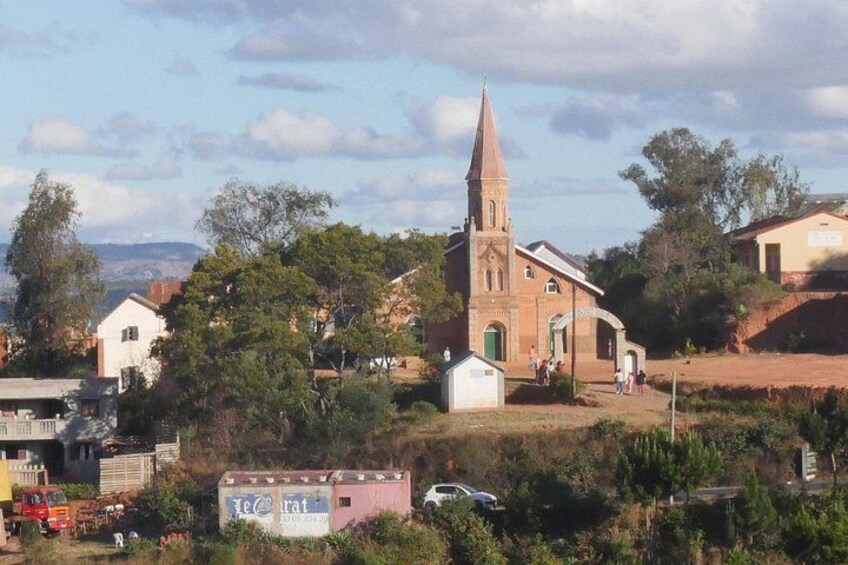 A church with a tall steeple, surrounded by trees and buildings. 3
