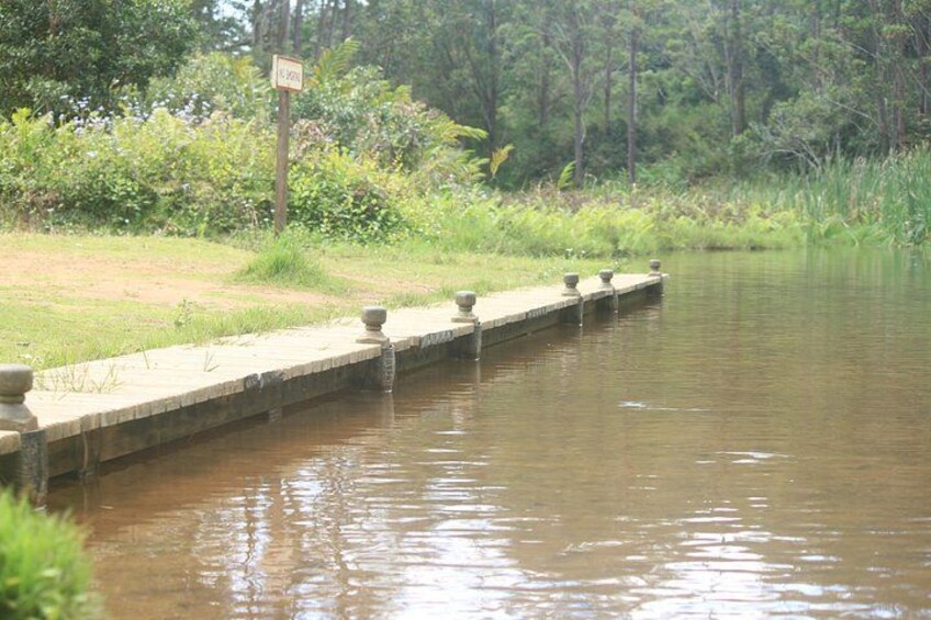 Une rivière paisible, bordée d’une berge en béton et agrémentée d’un panneau. 5
