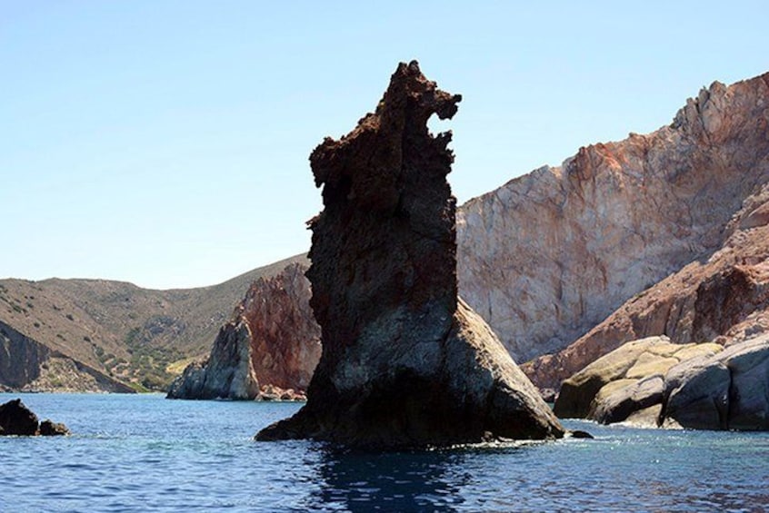 A rocky formation in a body of water with surrounding hills. 4
