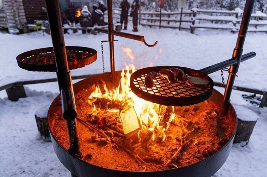 Lejrild med grill og stegepande, omgivet af sne. 5
