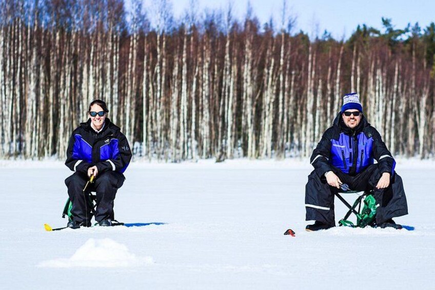 Two people in winter clothing sitting on the snow with skis and poles nearby. 4
