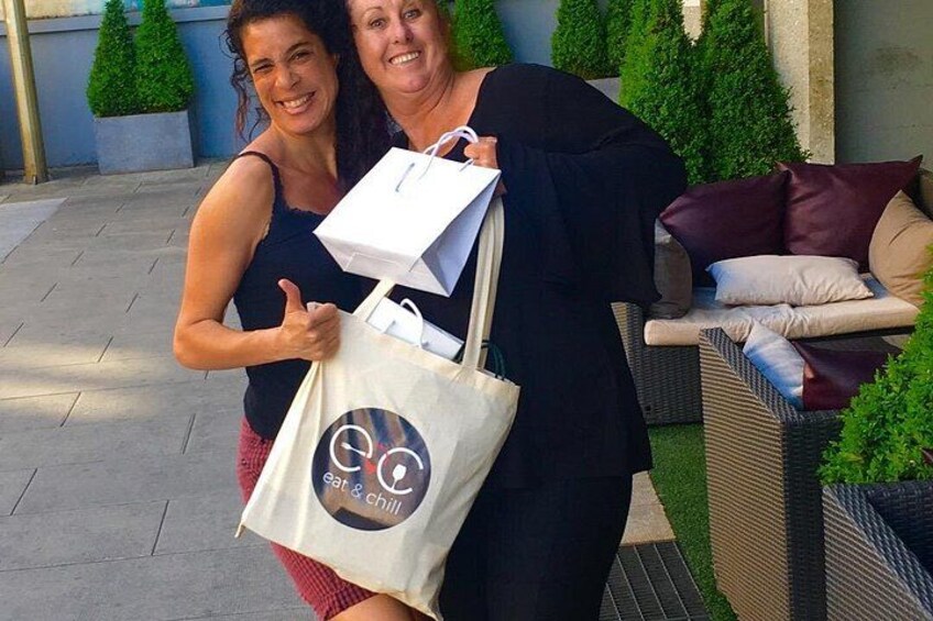Dos personas sosteniendo bolsas de compras con un logotipo que incluye 'eat & chill'. 2