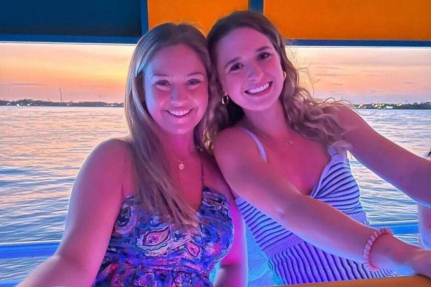 Two people on a boat with a sunset in the background. 2