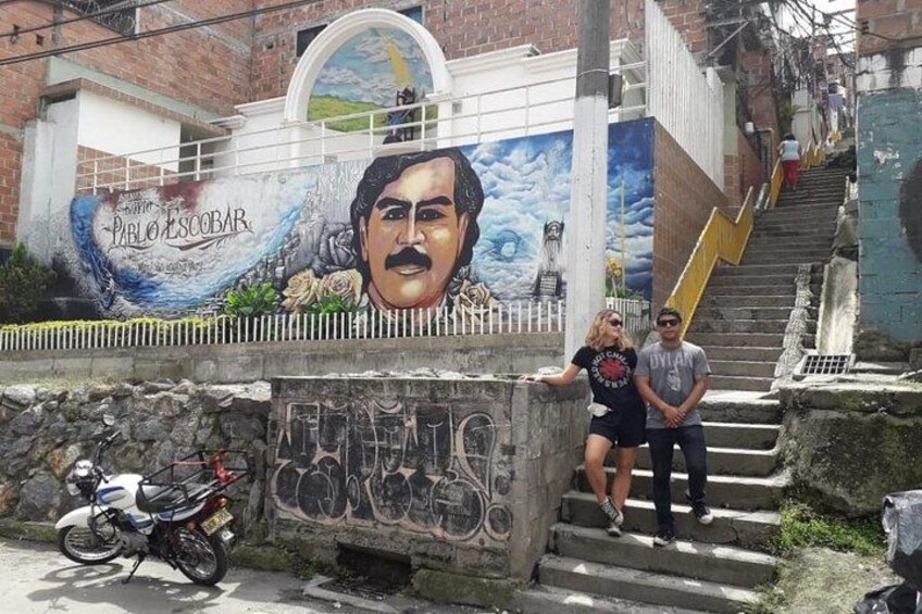 A mural with a man's face, a bicycle, and a staircase. 2