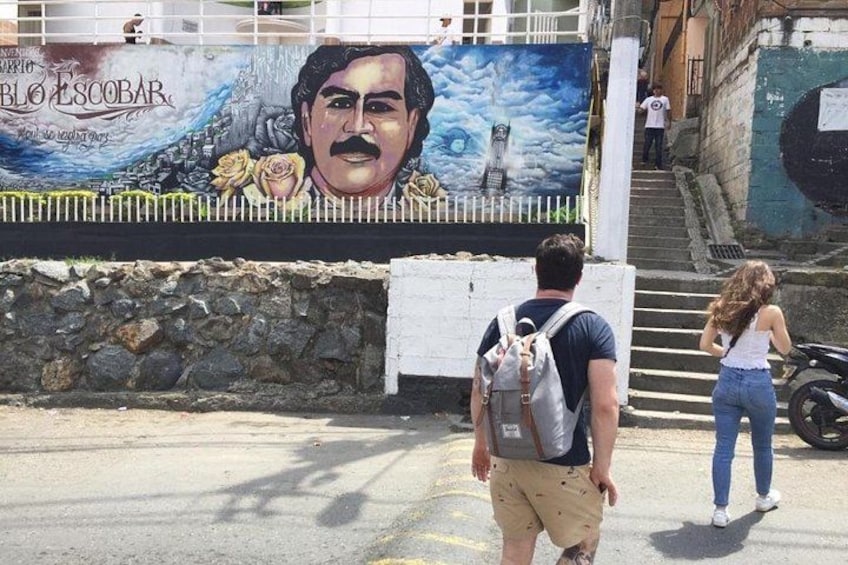 A mural with a person walking, a staircase, and a parked motorcycle. 5