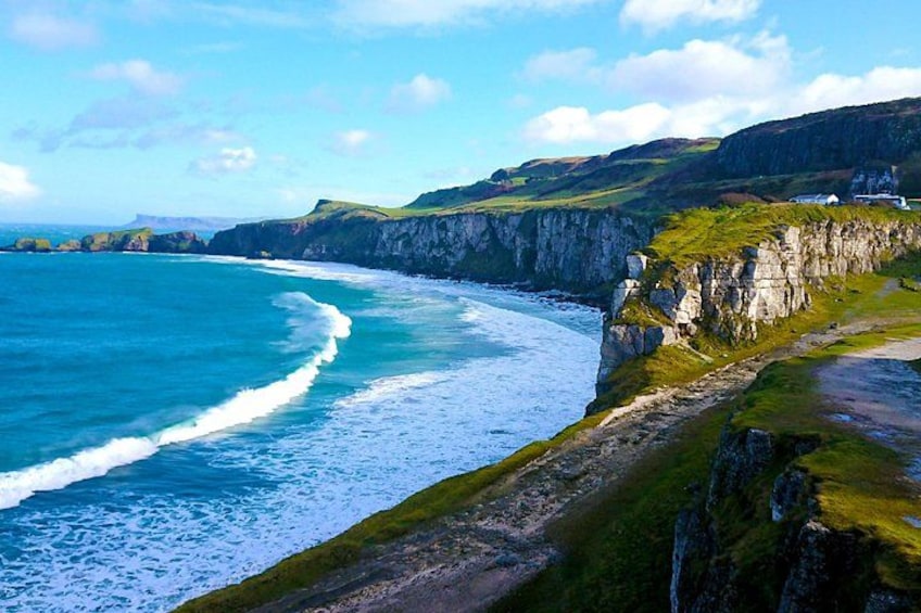 Un paysage côtier caractérisé par des falaises, des vagues déferlantes et un terrain herbeux. 3