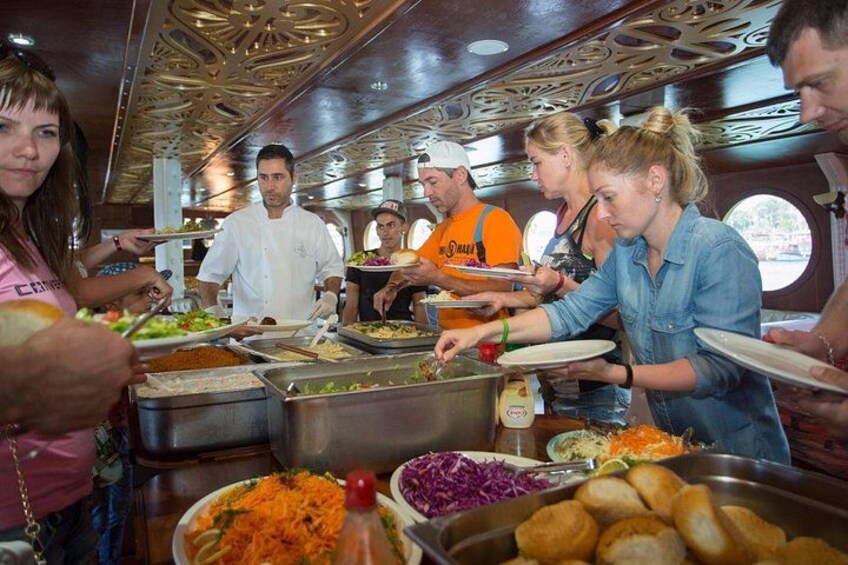 Gasten bedienen zichzelf van gerechten bij een buffet in een restaurant. 3